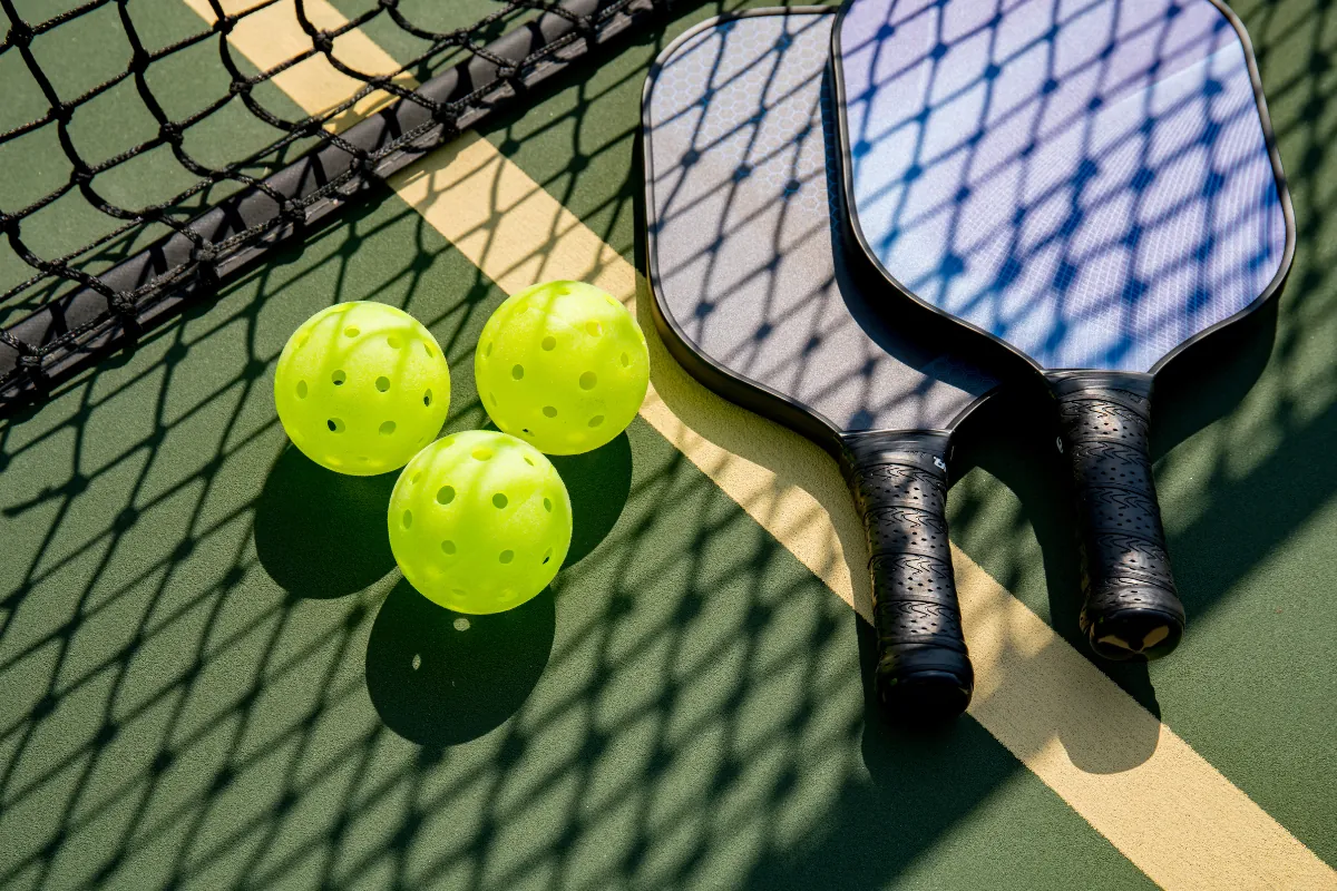 Pickleball paddles and balls on the estate court